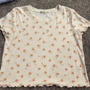 An off white crop top with colorful flowers.